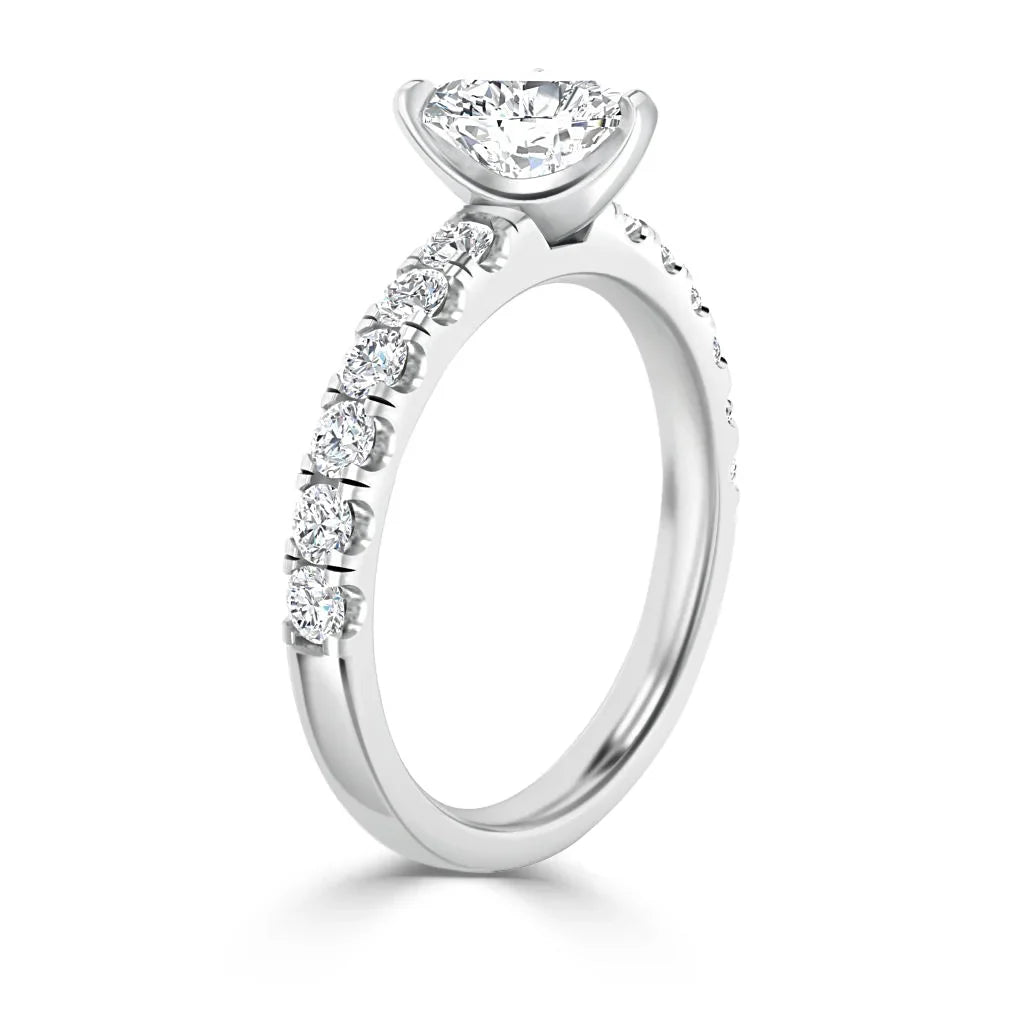 White gold ring with a round solitaire diamond and smaller diamonds set along the upper band.