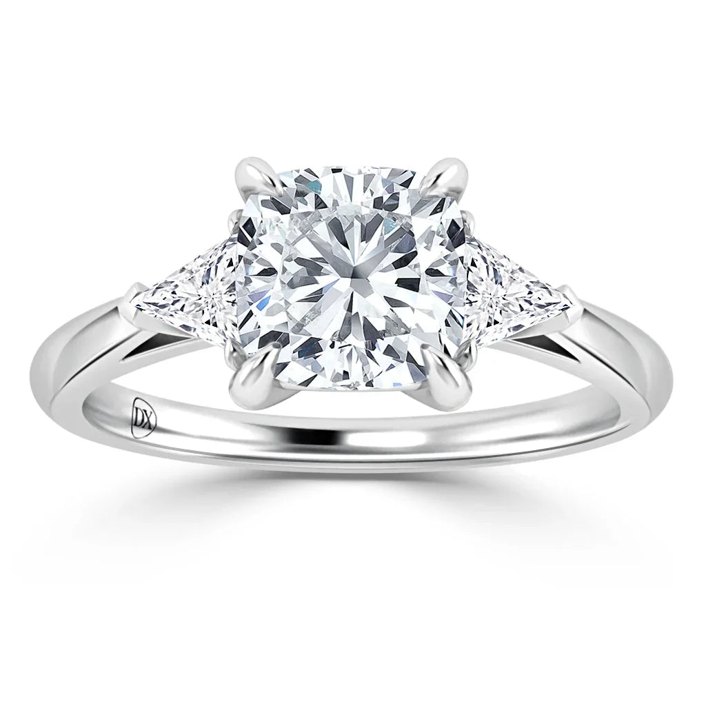 Platinum ring with a cushion-cut center diamond and two triangular diamonds on each side, on a polished band.