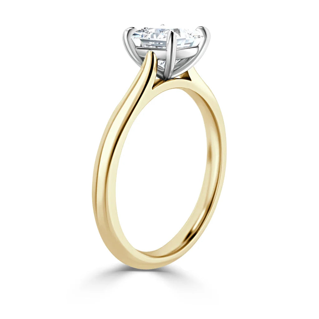 A gold solitaire engagement ring with a single round diamond set in a four-prong white gold setting.