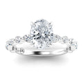 Oval diamond ring with twisted band featuring smaller diamonds, set in polished white metal.