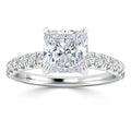 Platinum ring with a radiant-cut center diamond and round diamonds set along the band, shown on a white background.