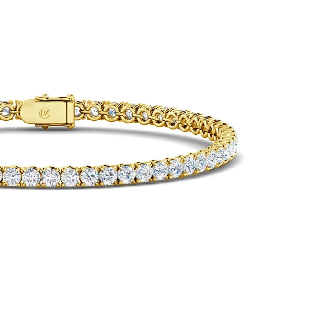 Gold tennis bracelet with a row of round white diamonds and a clasp, shown on a white background.