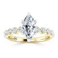 Gold ring with a marquise-cut center diamond and round diamonds along the band, set in prongs.