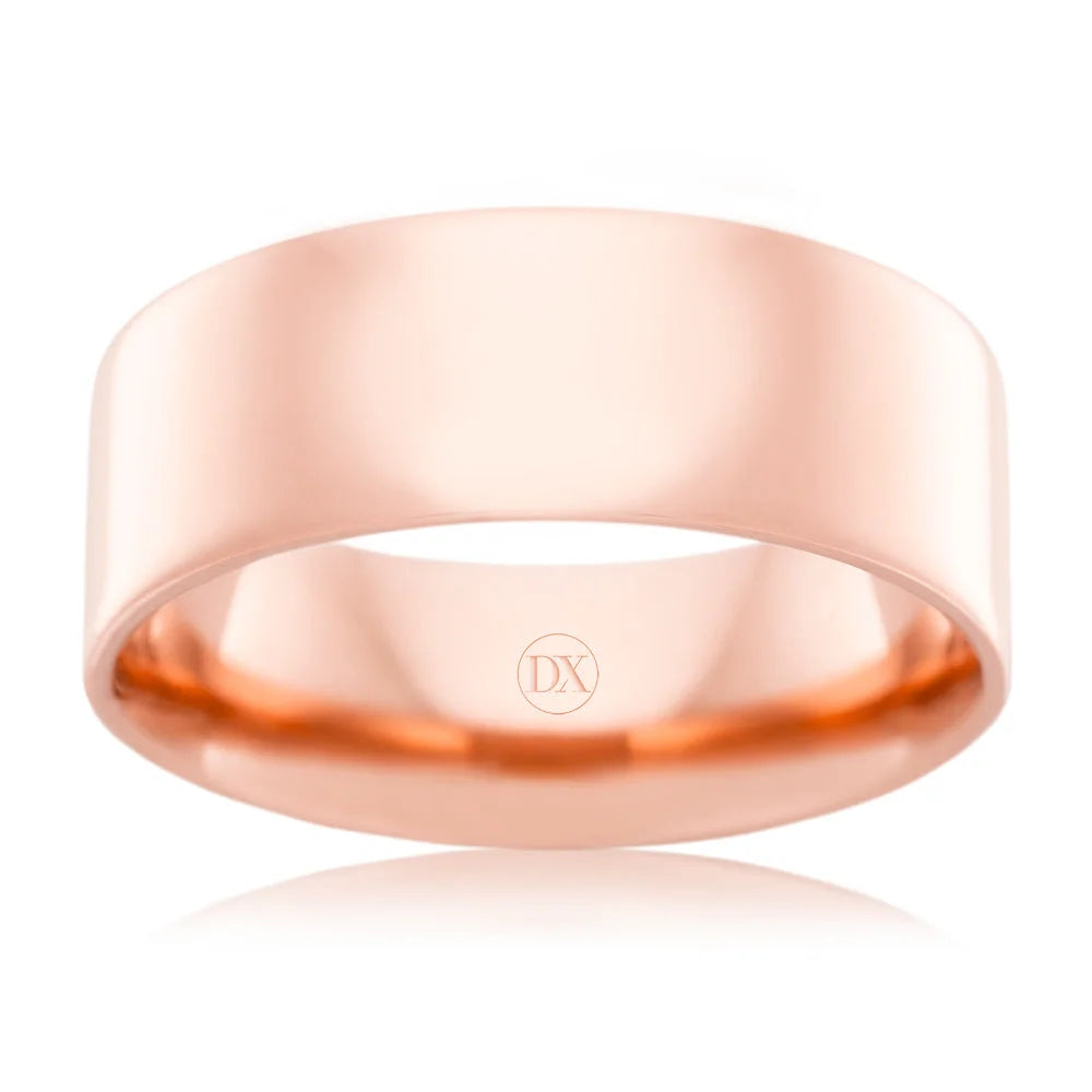 A plain, wide rose gold ring with a smooth, polished finish and DX engraved inside the band.