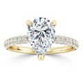 Gold ring with a large pear-shaped diamond center and a band encrusted with small round diamonds.