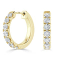 Gold hoop earrings set with a row of round, sparkling white diamonds on the front side.