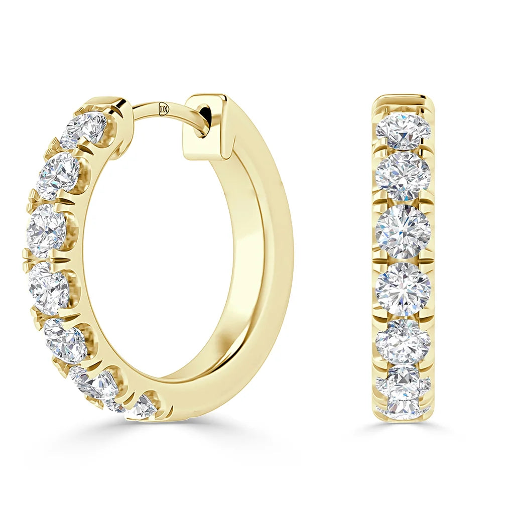Gold hoop earrings set with a row of round, sparkling white diamonds on the front side.