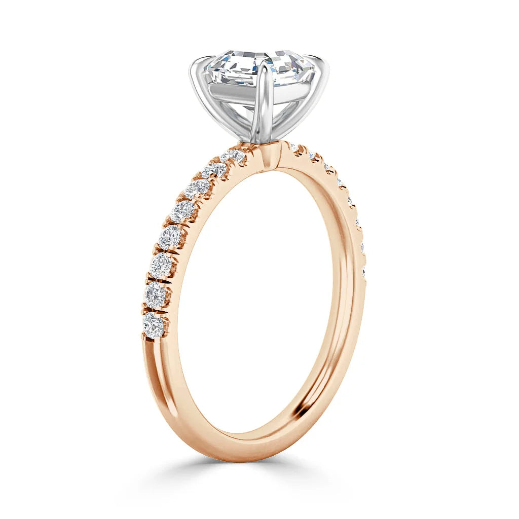Rose gold diamond ring with pavé band and a large round solitaire diamond in a raised prong setting.