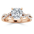 A rose gold ring with a cushion-cut center diamond and a twisted, diamond-accented band.