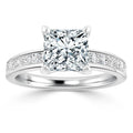 A platinum ring with a large princess-cut diamond and smaller diamonds set along the band.