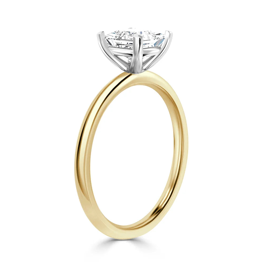 A gold band ring with a round diamond solitaire set in a white gold prong setting, shown on a white background.