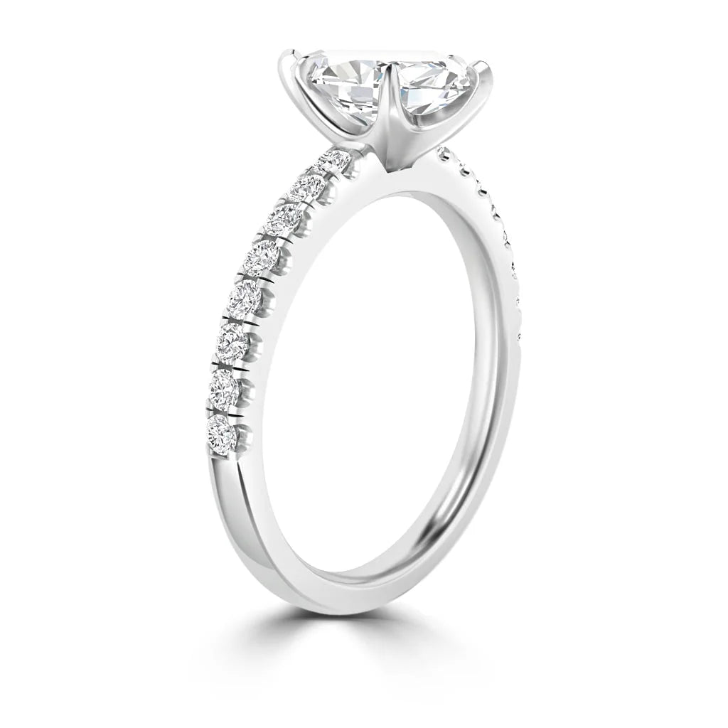A white gold engagement ring with a large solitaire diamond and smaller diamonds set along the band.