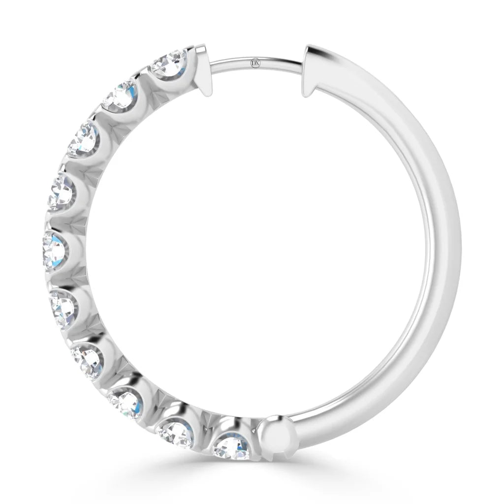 A silver hoop earring with embedded round white gemstones along half of its outer edge.