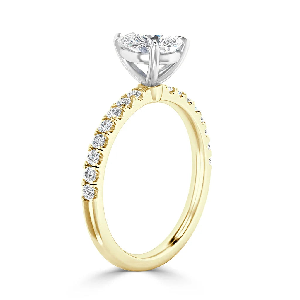 A gold ring with a round diamond solitaire and smaller diamonds set along the top half of the band.