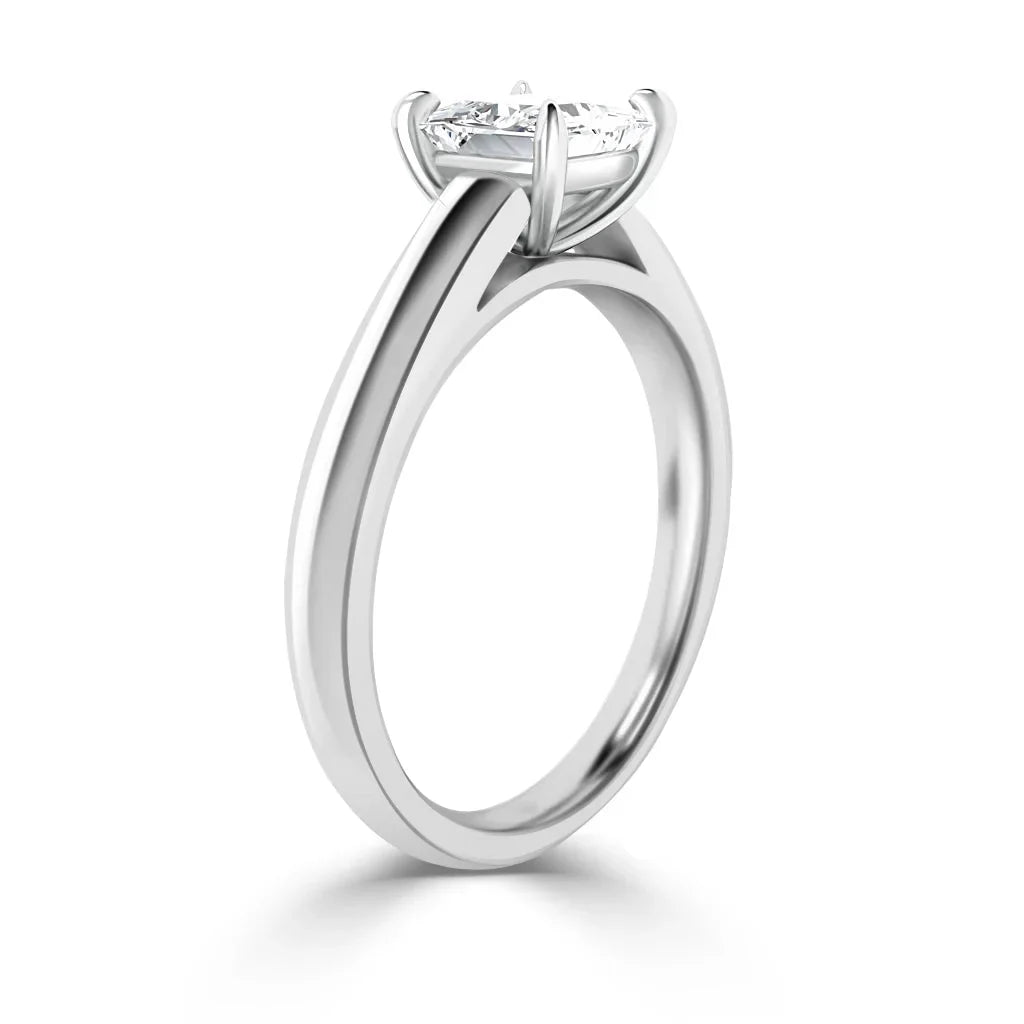 Side view of a solitaire diamond engagement ring with a sleek, polished white gold band and prong setting.