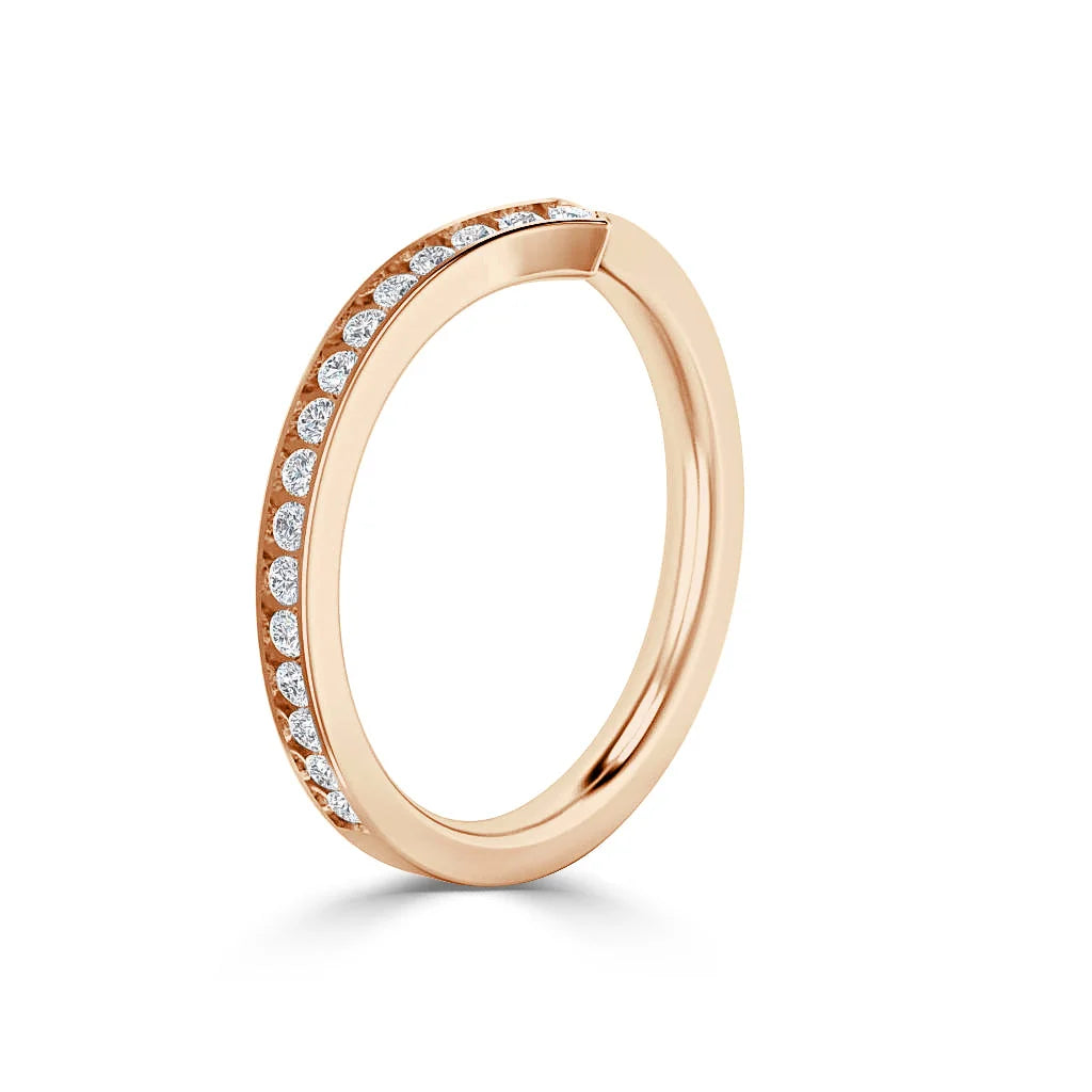 Rose gold ring with a row of round white diamonds set along the upper half of the band, on a white background.