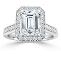 Emerald-cut diamond ring with a halo of smaller diamonds on a white gold band, also accented with diamonds.