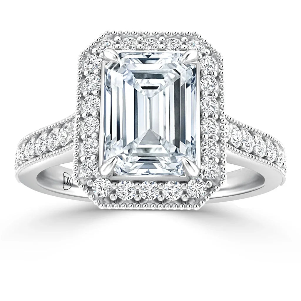 Emerald-cut diamond ring with a halo of smaller diamonds on a white gold band, also accented with diamonds.