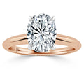Oval diamond solitaire ring with rose gold band and four prongs, displayed on a white background.