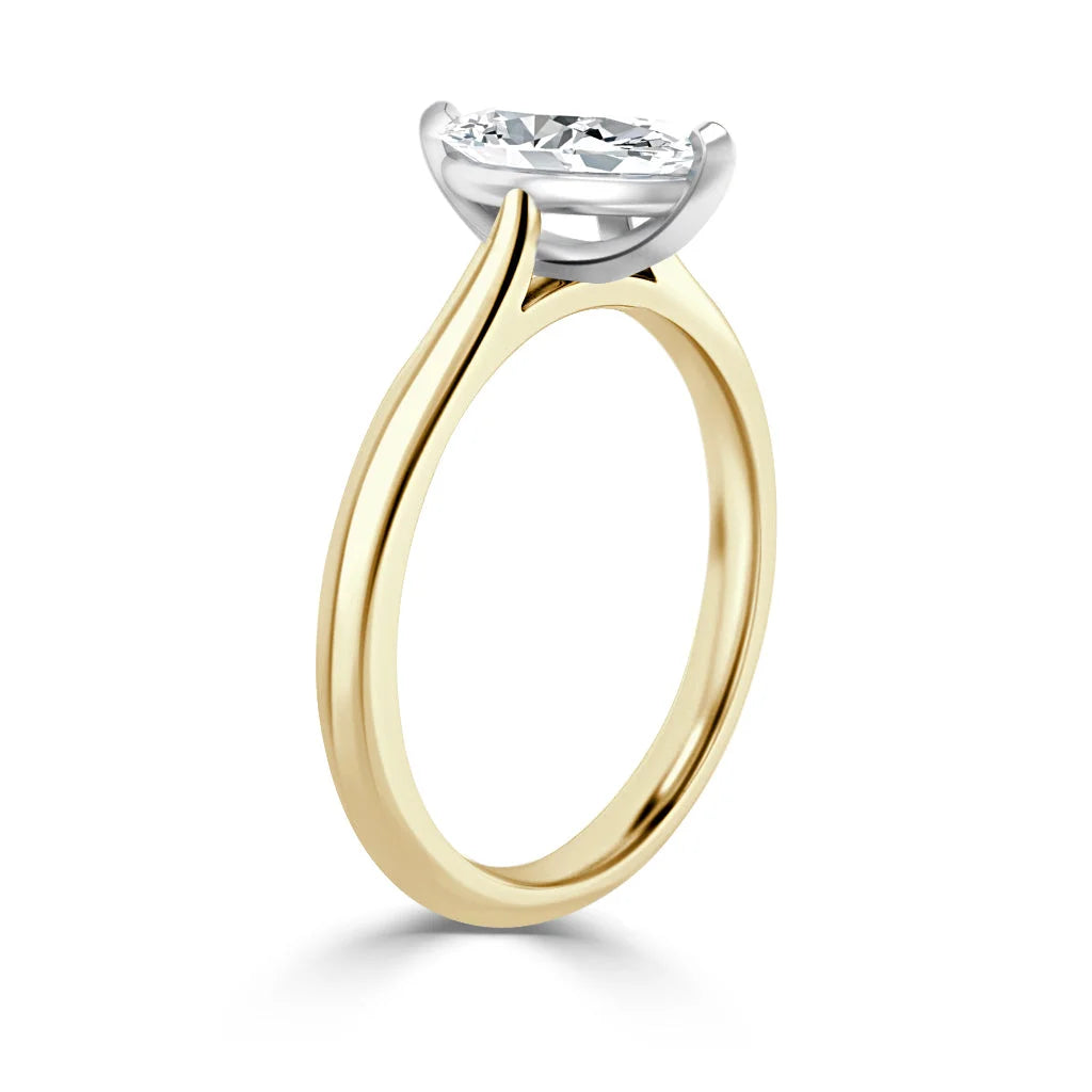 A gold ring with a thin band and a large round diamond in a raised prong setting, viewed from the side.