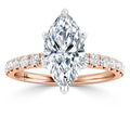 Rose gold ring with a large marquise-cut diamond and small round diamonds on the band, set on a white background.