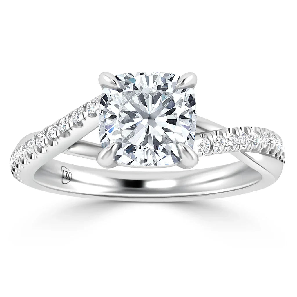 White gold ring with a cushion-cut diamond center and pave diamonds on a twisted band, displayed on a white background.