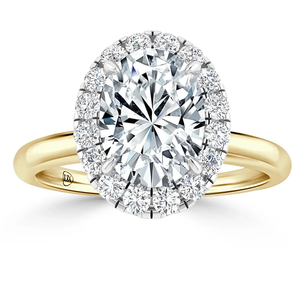 Gold band ring with large oval diamond center, surrounded by a halo of smaller round diamonds, on a white background.
