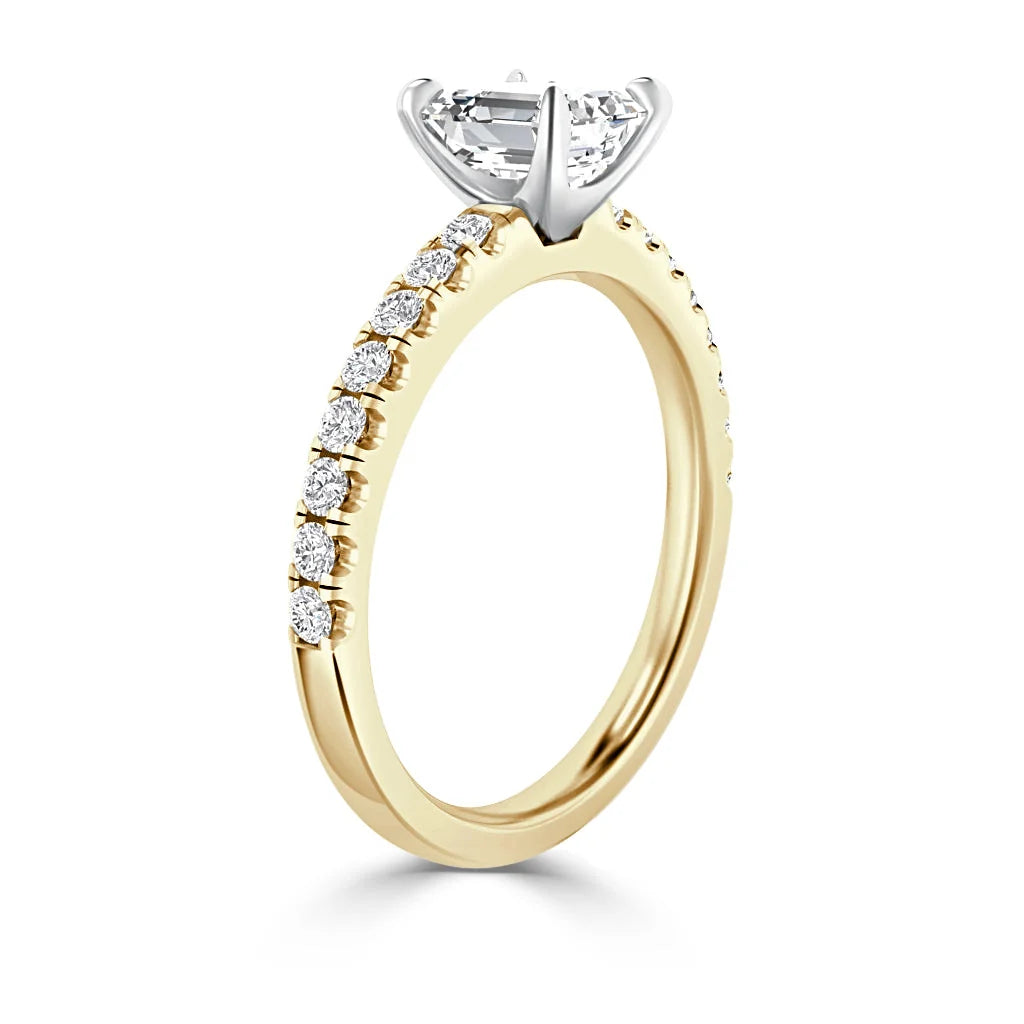 Gold engagement ring with small diamonds on the band and a large solitaire diamond in a white gold prong setting.