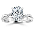 A white gold ring with a large oval diamond center and a twisted band accented with small diamonds.