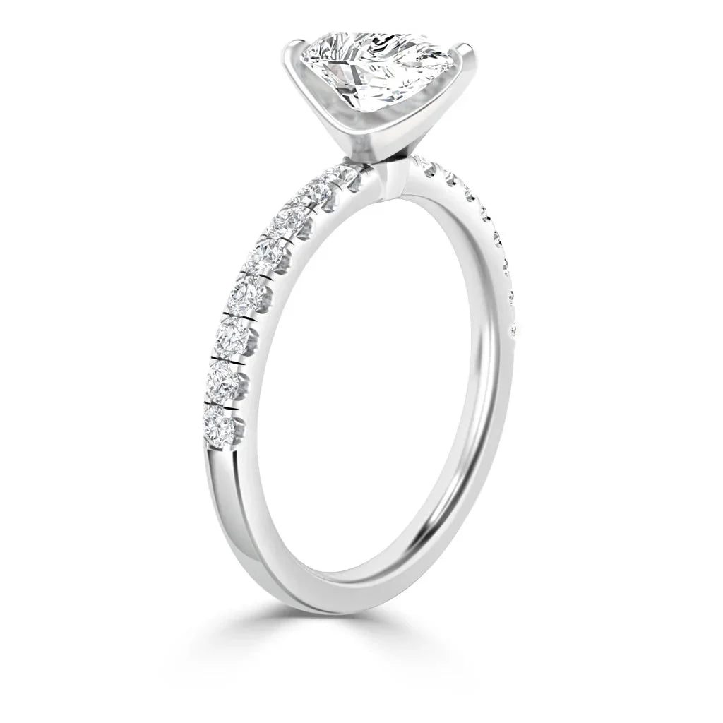 A white gold ring with a large round solitaire diamond and small diamonds set along the band.