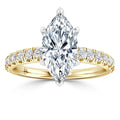 A marquise-cut diamond ring with a yellow gold band accented by round diamonds, shown on a white background.