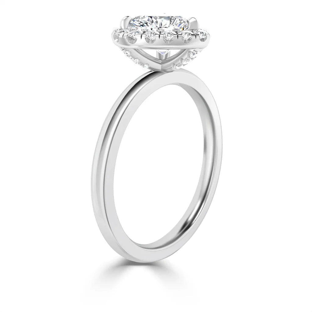 Side view of a white gold ring with a round center diamond and a halo of smaller diamonds around the setting.
