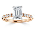Emerald-cut diamond ring with a rose gold band, accented by small round diamonds along the band.