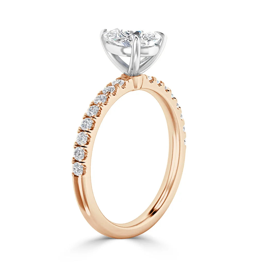 A rose gold ring with side diamonds and a large round white diamond in a white gold prong setting.