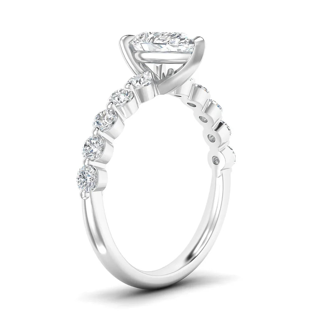 Side view of a silver ring with round diamonds along the band and a large marquise-cut center diamond in a prong setting.