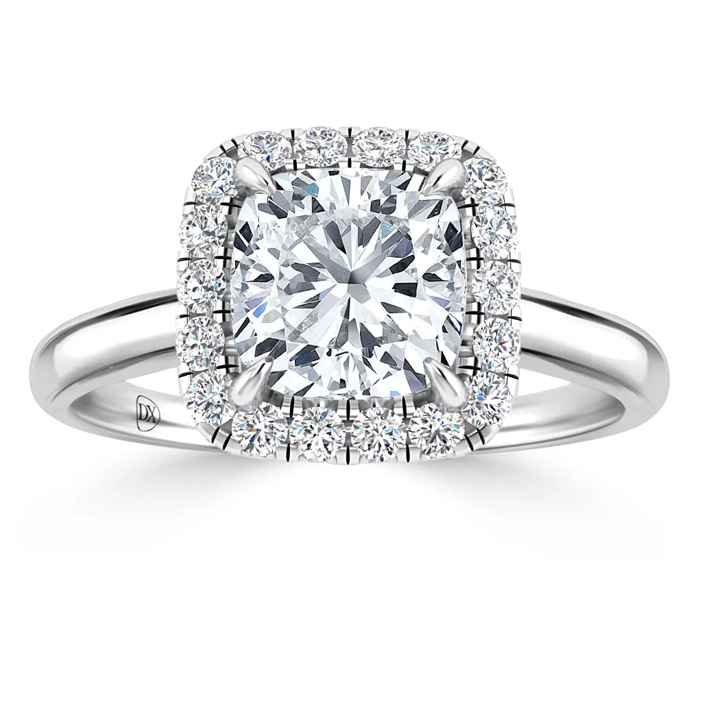 A cushion-cut diamond ring with a double halo of small diamonds on a polished white gold band.