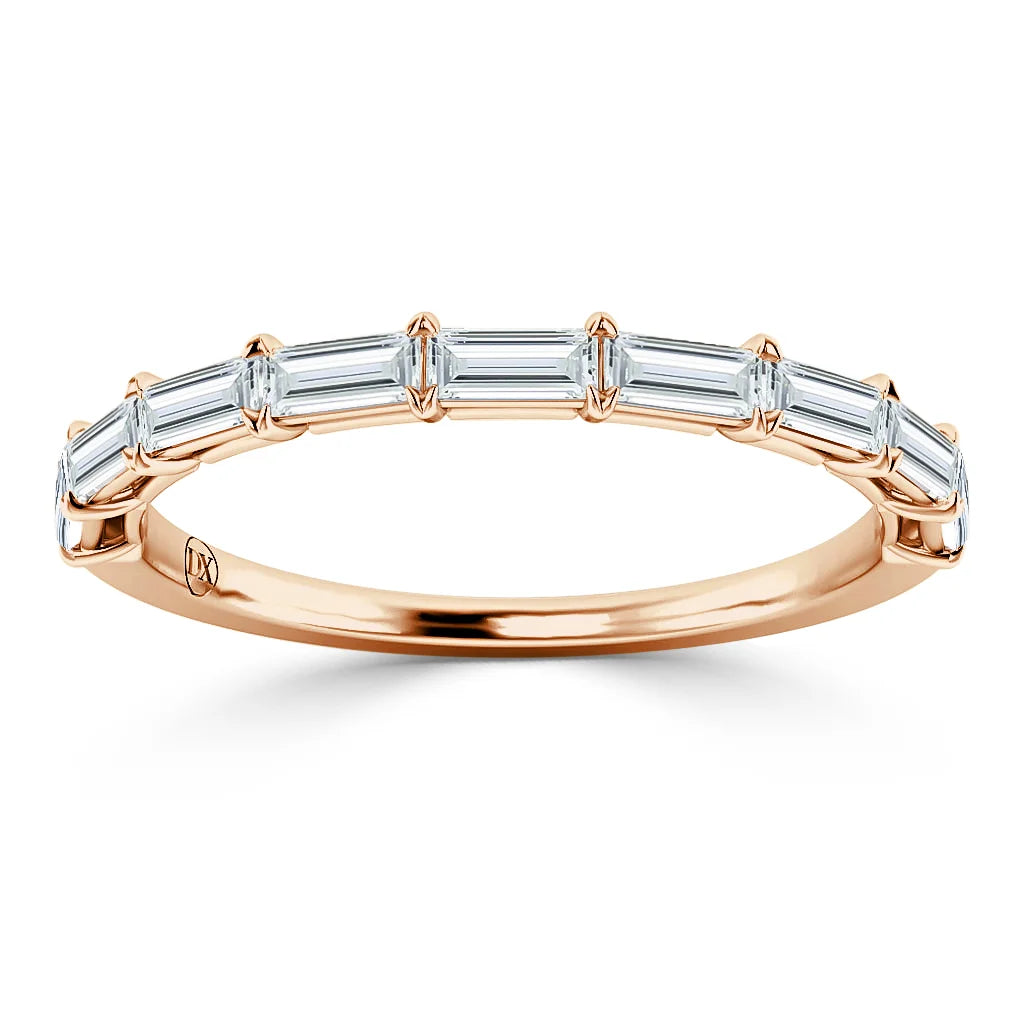 A rose gold ring with seven rectangular baguette-cut diamonds set across the top in a single row.