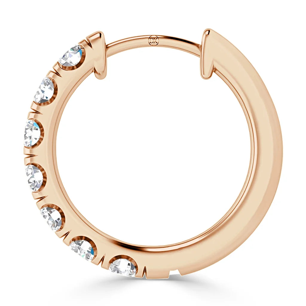 A rose gold hoop earring with seven clear gemstones set along the lower half of the hoop.