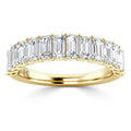 A gold band ring set with a row of rectangular emerald-cut diamonds in a shared prong setting.