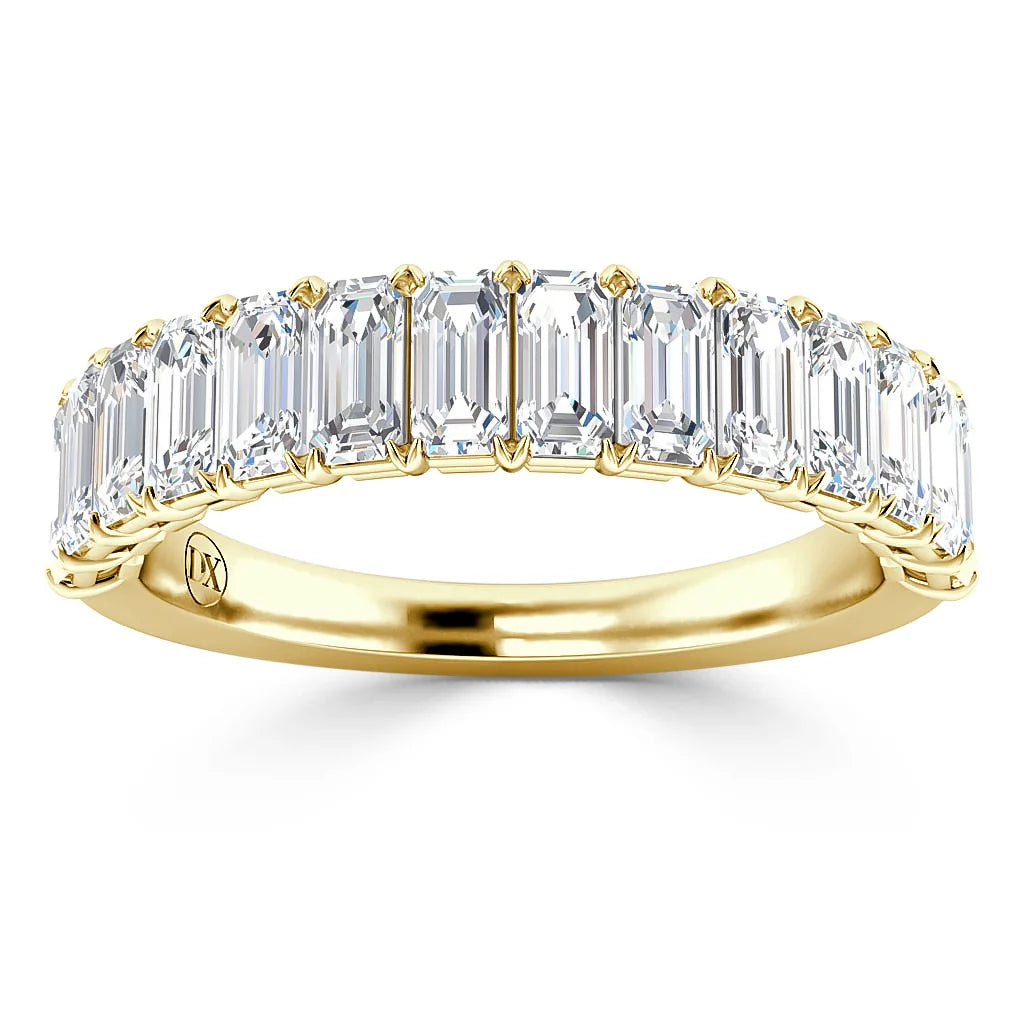 A gold band ring set with a row of rectangular emerald-cut diamonds in a shared prong setting.