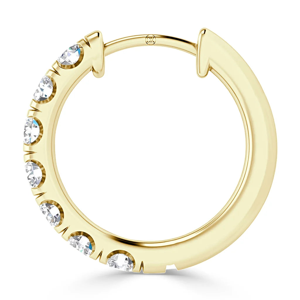 A gold hoop earring with seven clear round gemstones set in a row along one side.