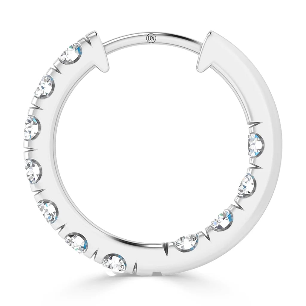 A silver hoop earring with embedded round clear gemstones along one side, shown on a white background.