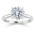 A silver solitaire ring with a round, brilliant-cut diamond set in a four-prong setting.