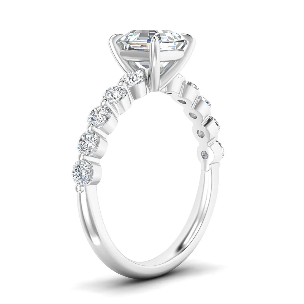 Side view of a white gold ring with round diamonds on the band and a large center stone in a prong setting.