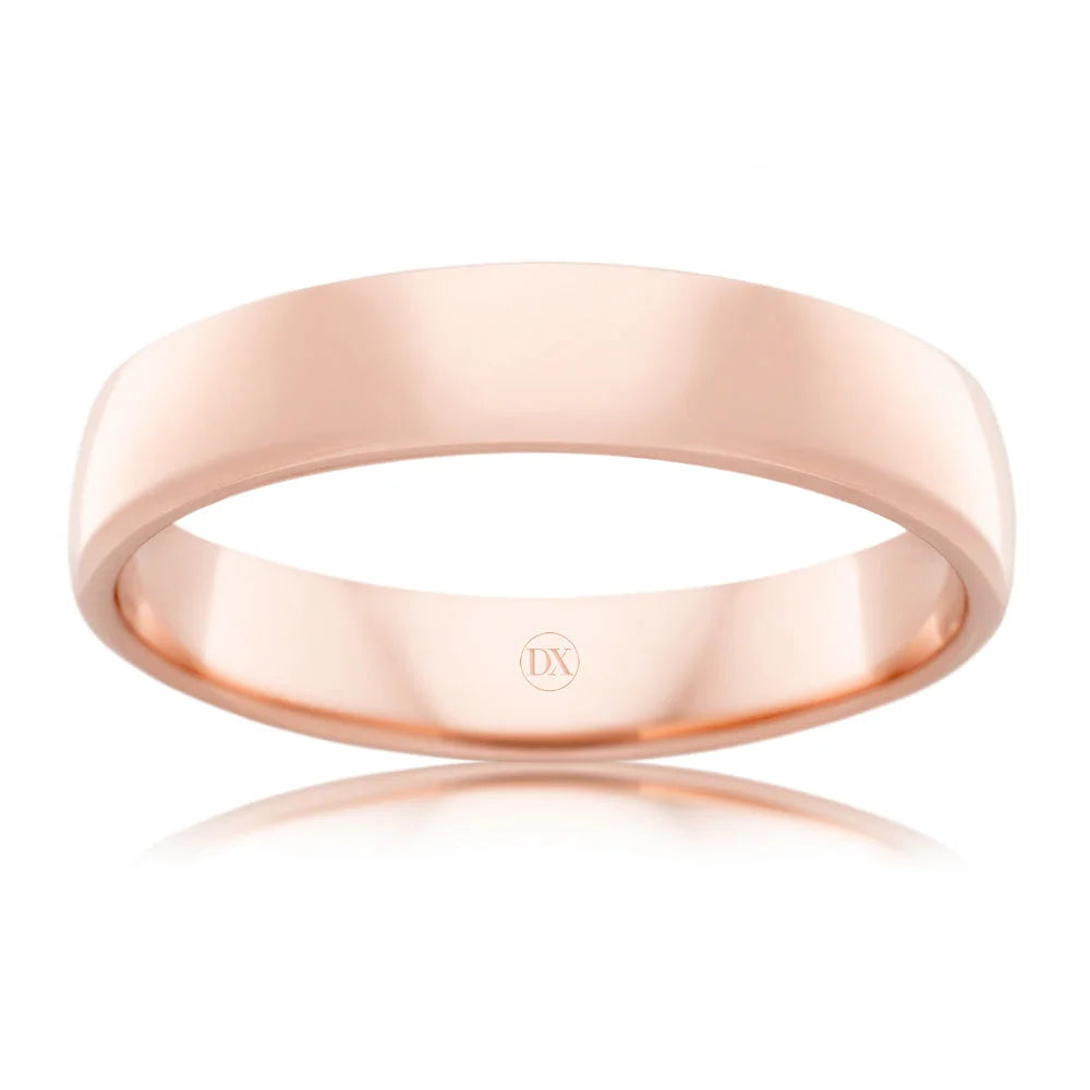 A plain, polished rose gold ring with a flat profile and a small DX engraved inside the band.