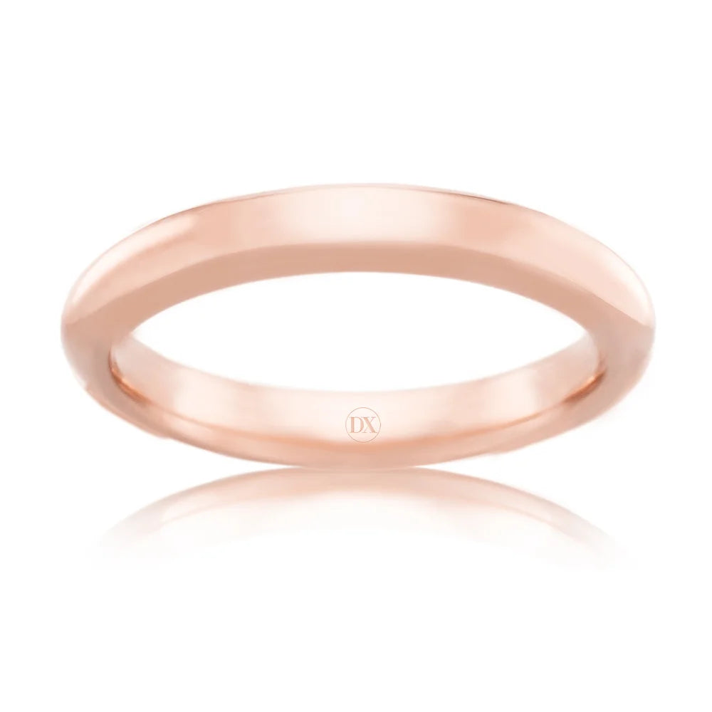 A simple, polished rose gold ring with a smooth, rounded band and a small DX engraving inside.