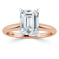 Emerald-cut diamond solitaire ring with a rose gold band and white gold prongs, viewed from the front.