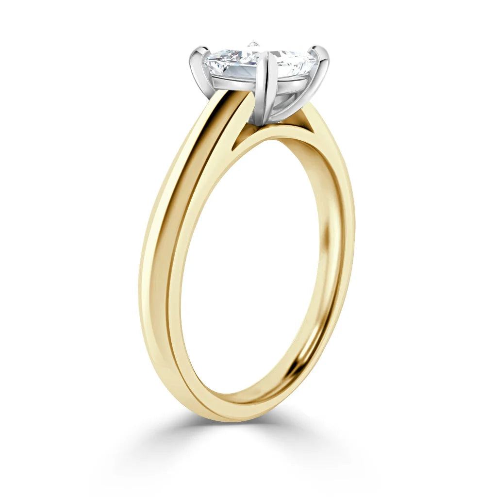 A gold band engagement ring with a round, prong-set diamond solitaire on a white background.
