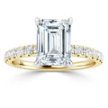 Emerald-cut diamond ring with pavé diamonds on a yellow gold band, viewed from the front.
