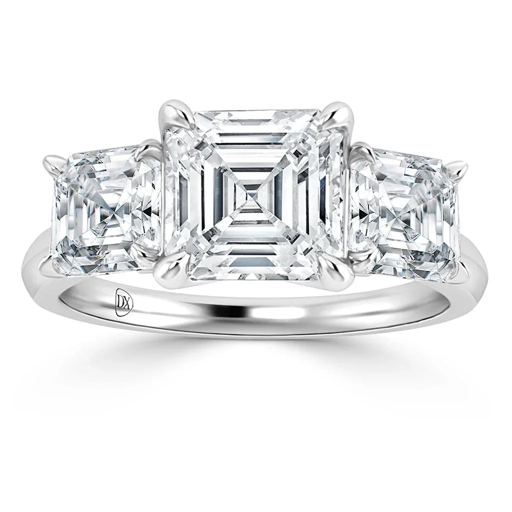 Platinum ring with three square-cut diamonds, the center stone larger than the two on each side.